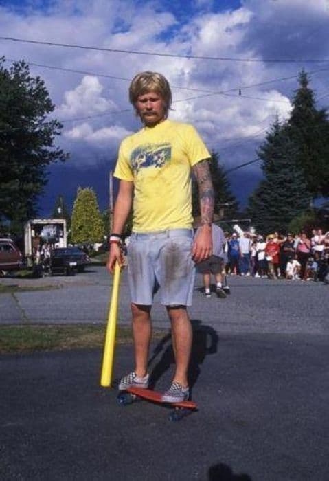 DIY Tom Delonge - Blink 182 - First Date Video Kostüm mit Perücke blond, Zerrissene kurze Jeans Hose, Vans Slipper Schachbrettmuster, Schweißband rot/weiß/blau, Piercing Lippe